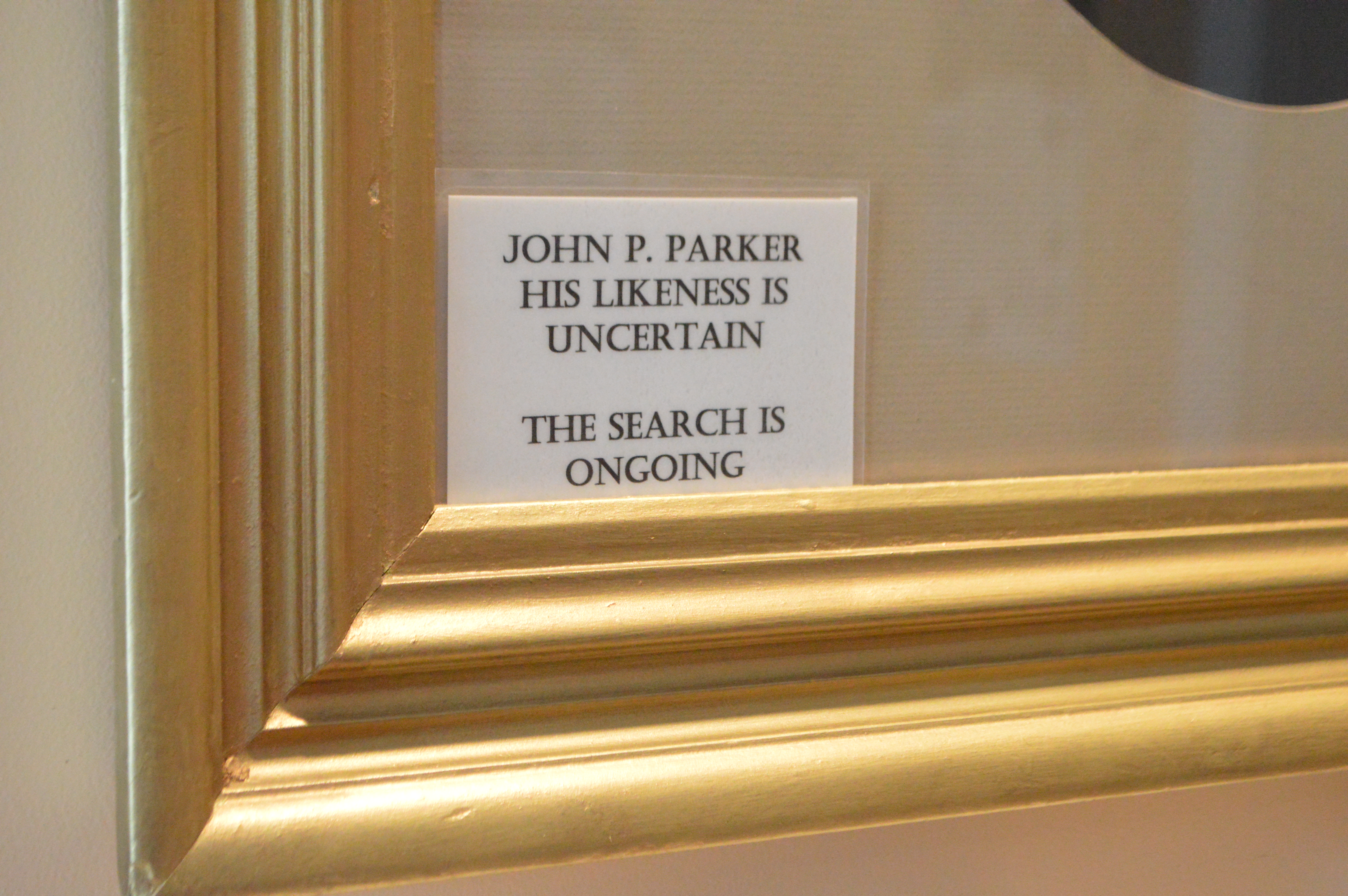 A frame within the John Parker home referencing the ongoing search for his likeness
